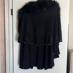 Faux fur cape with pearl studs that outline the cape.